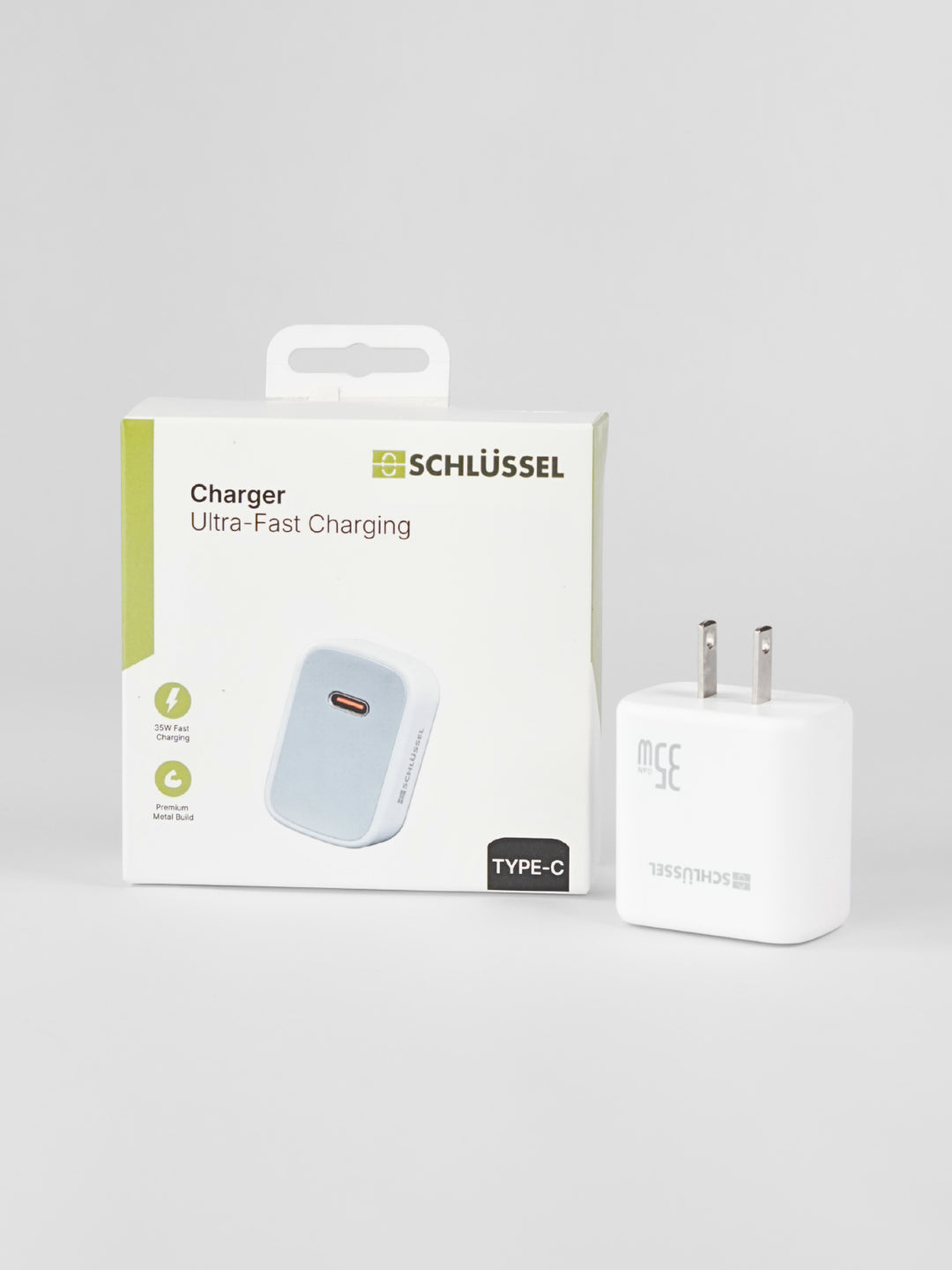 A white Schlüssel 35W Type-C ultra-fast wall charger block standing next to its retail product packaging box on a seamless light gray background
