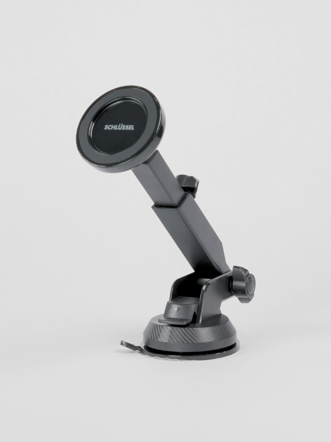 Black Schlüssel magnetic car phone holder showing its front circular magnetic face, telescopic arm, and dual adjustment knobs, positioned on a seamless light gray background